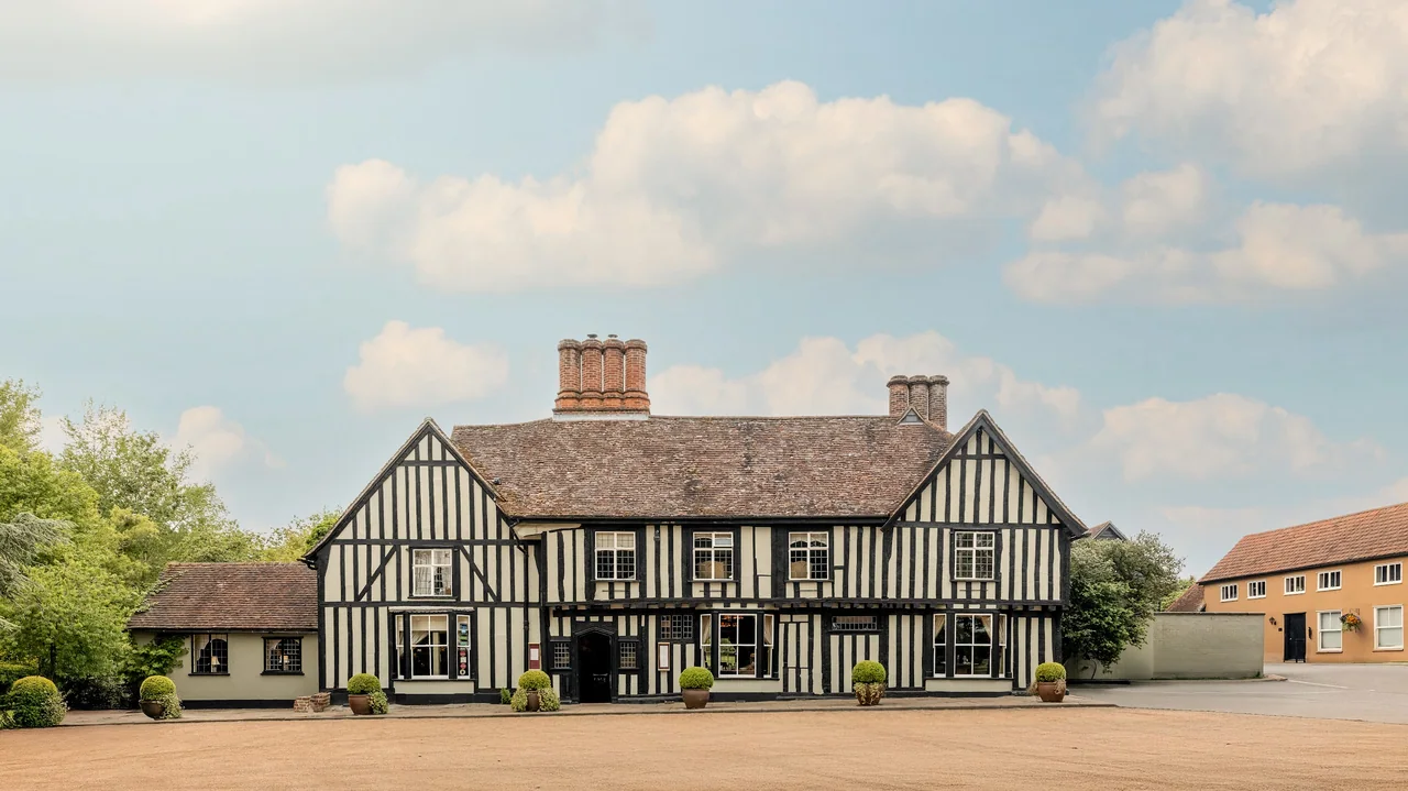 Traditional Tudor-style building with black timber framing and white infill panels