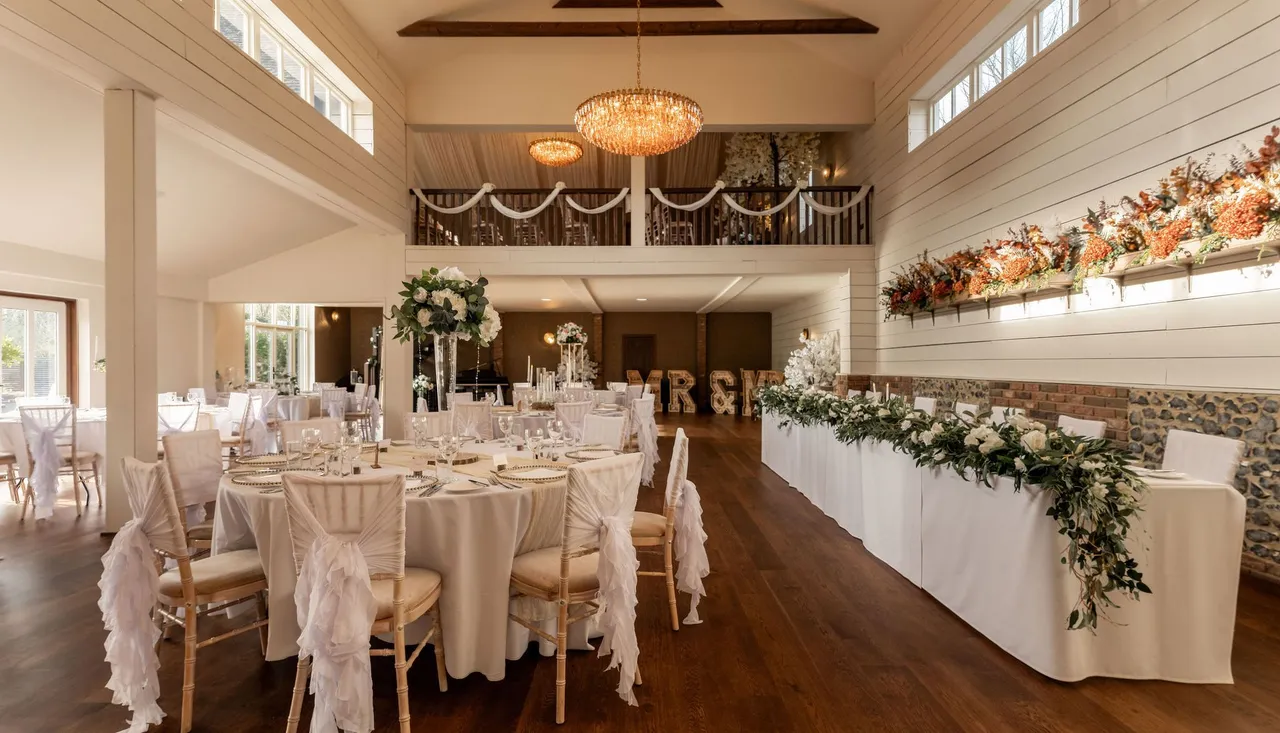 Elegant wedding reception hall with decorated tables and floral arrangements